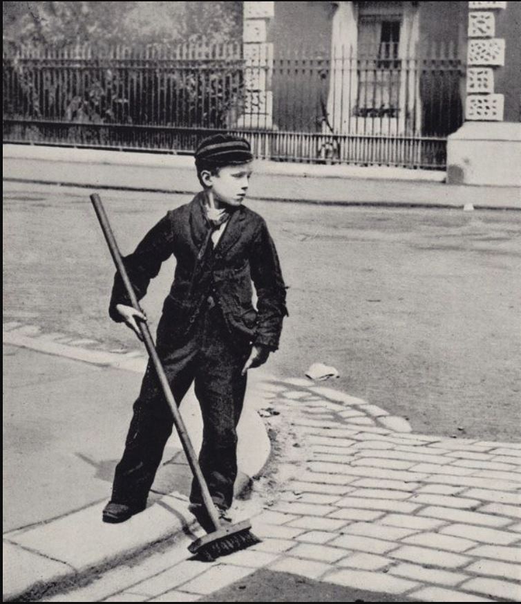 Boy cleaning street, ca. 1900.
